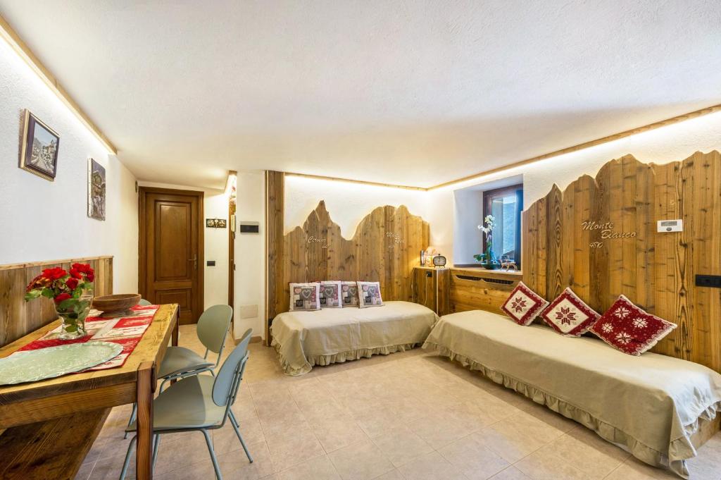a hotel room with two beds and a desk at Il Nido di Letizia in Châtillon