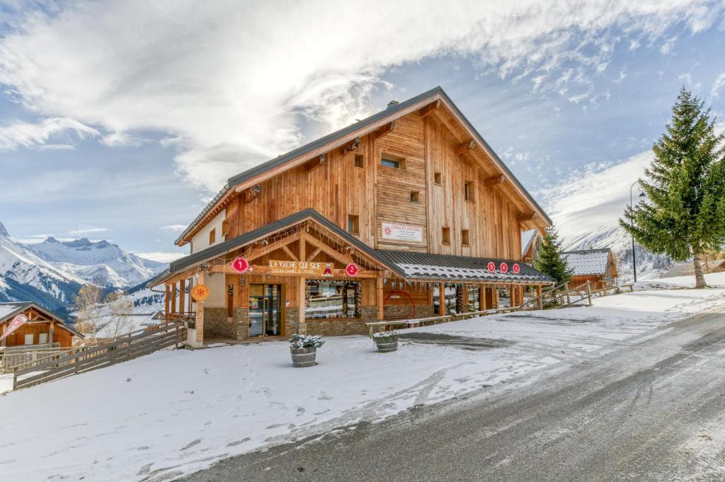 a large wooden building with snow on the ground at Chalet Arvina in Saint-Jean-dʼArves