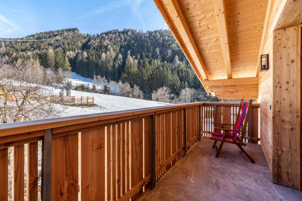 a rocking chair on a balcony with a view at Balbeinhof Apt Gams in Luson