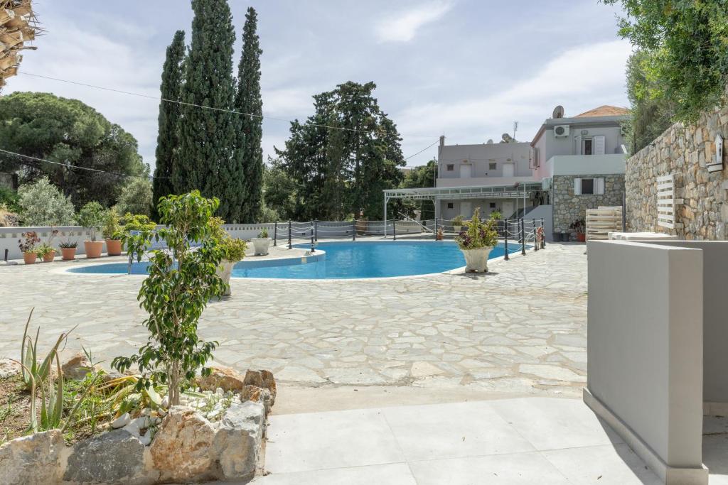 a villa with a swimming pool and a house at Ilias Studios Sevasti Kalymnos in Panormos Kalymnos