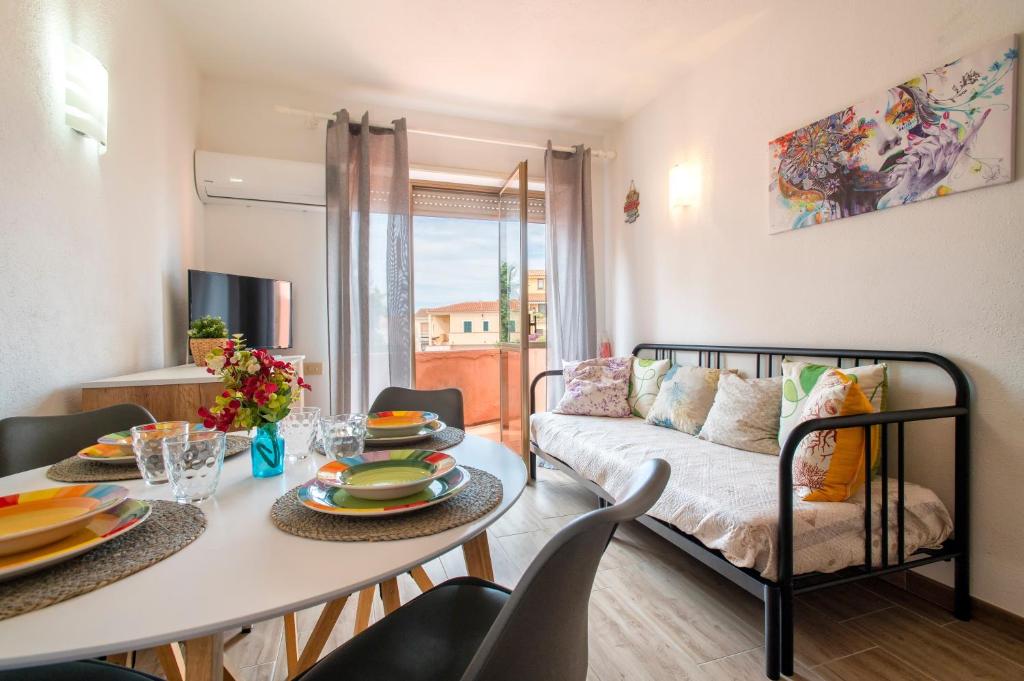 a living room with a table and a couch at Endless Summer Apartment in Isola Rossa