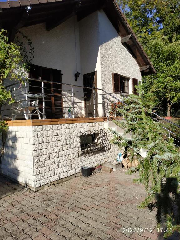 ein weißes Backsteinhaus mit einem Balkon an der Seite in der Unterkunft Maison de vacances Diff in Puttelange-aux-Lacs