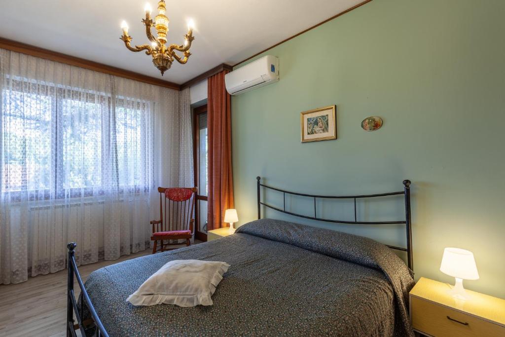 a bedroom with a bed and a chandelier at Casa Cesarina in Massa