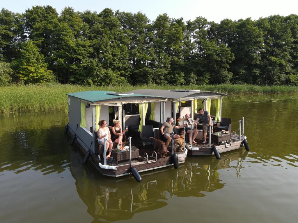 Eine Gruppe von Menschen, die auf einem Boot auf dem Wasser sitzen in der Unterkunft Floss Priepert 2 in Priepert