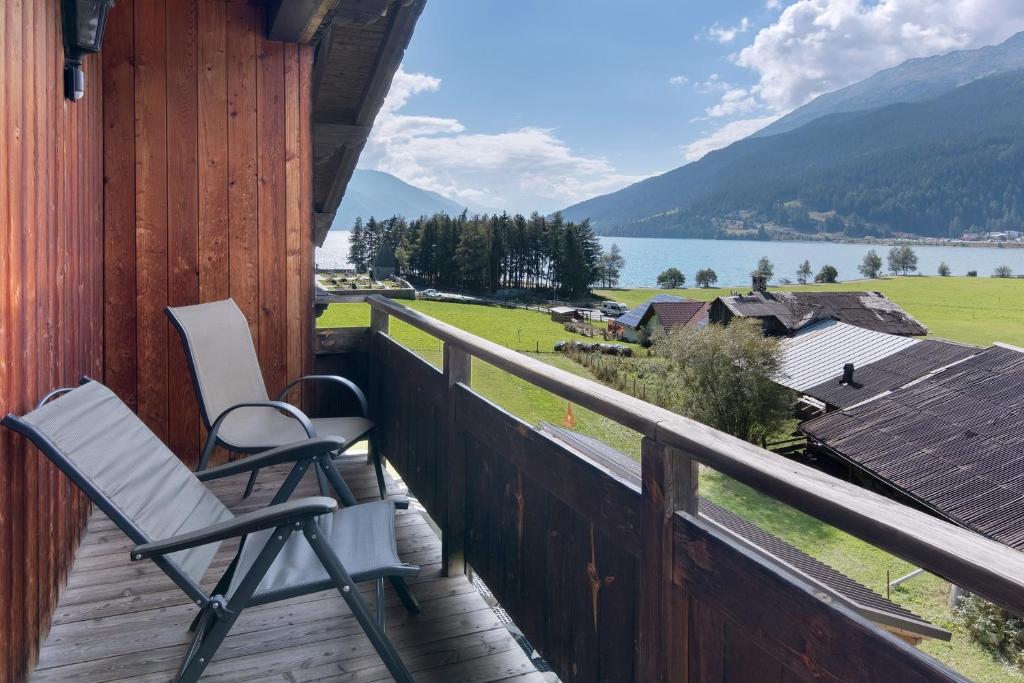 a porch with two chairs and a view of a lake at Appartement Egart 2 in Resia