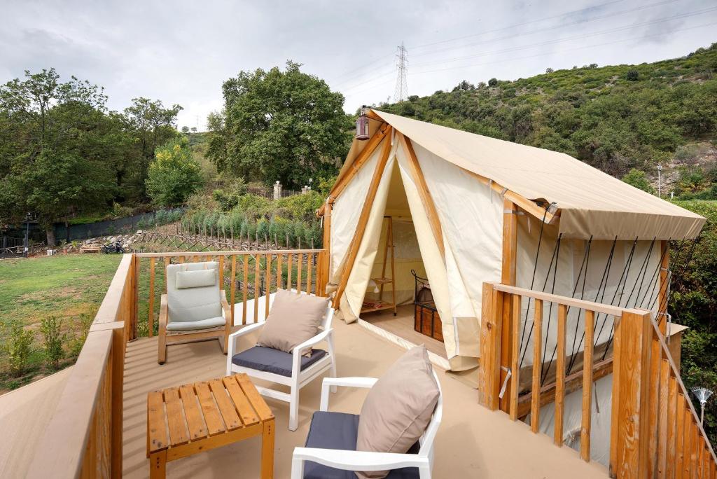 a gazebo with chairs and tables on a deck at Glamping Ripa Garden Montestella in Salerno