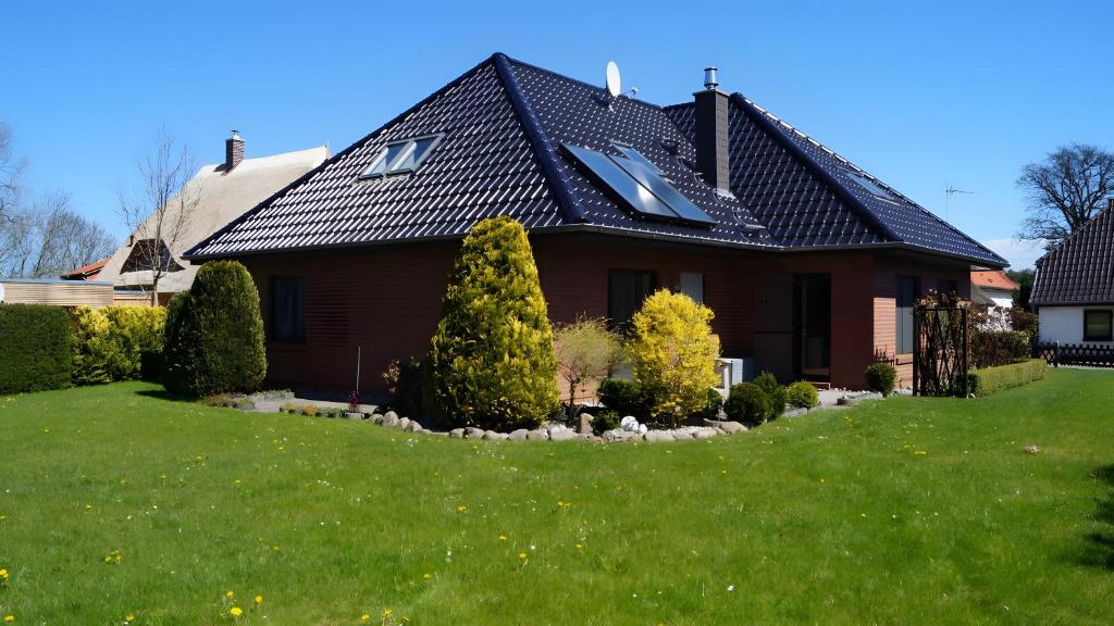 a house with a gambrel roof with a green yard at Fewo Hiddensee, 2 Personen 40 M² in Wiek auf Rügen