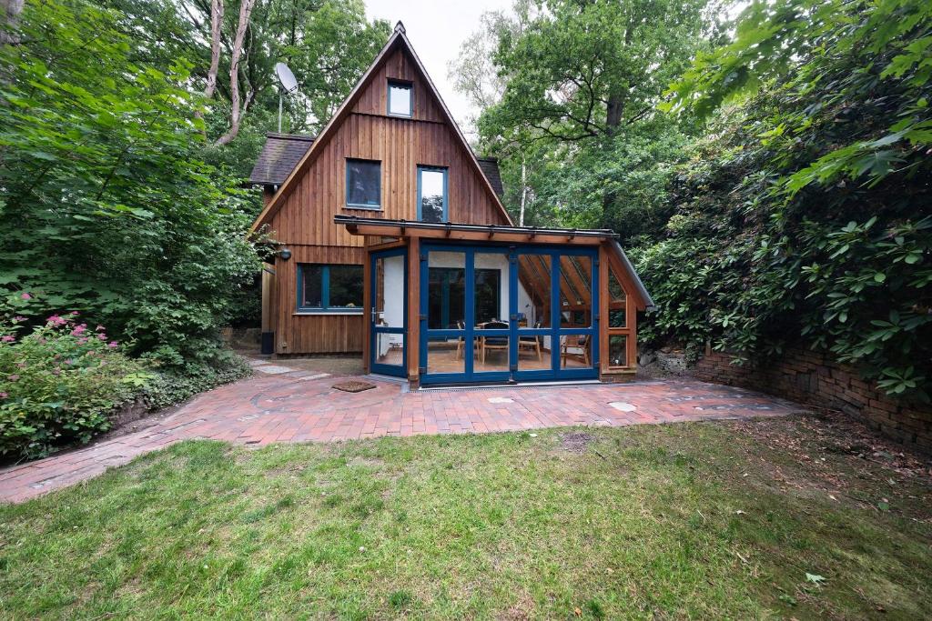 a small wooden house with a glass door at Ferienhaus am Brandorffsee in Wiefelstede