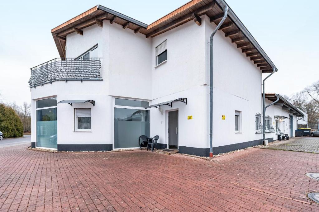 a white house with a brick driveway at Saarglück - W4 in Beckingen