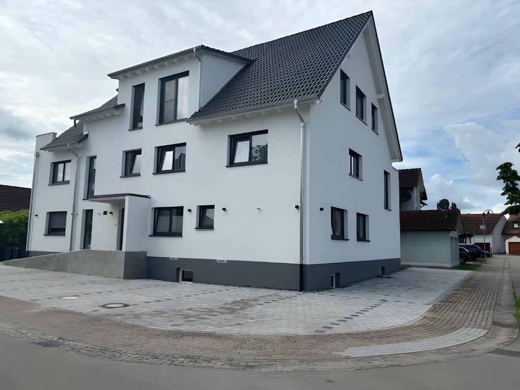a white building with a black roof at Fewo im Eichengrund in Rheinhausen