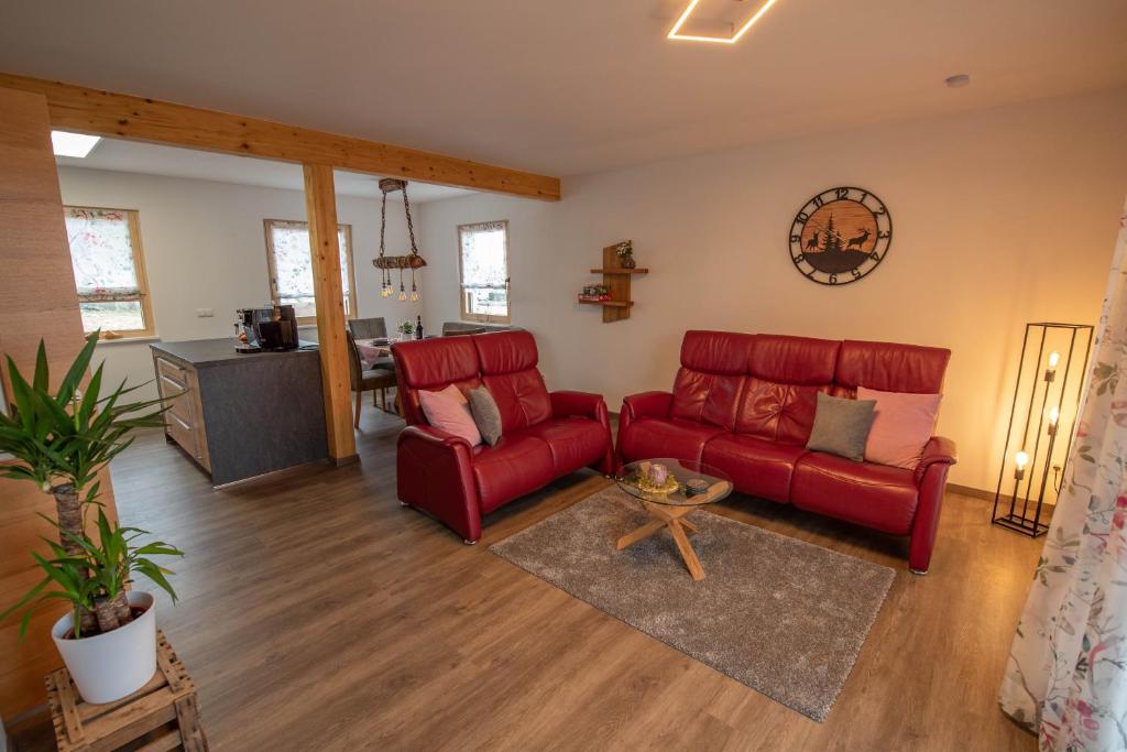a living room with a red couch and a table at Bergstern in Freudenstadt