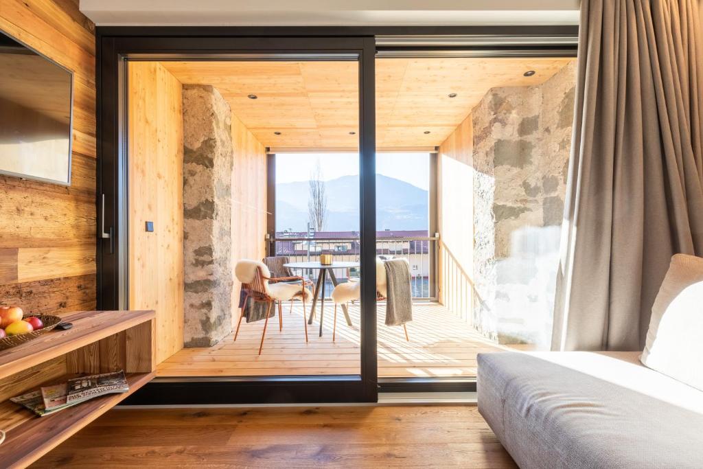 a bedroom with a balcony with a table and chairs at Innerbachlerhof - Mut in Postal