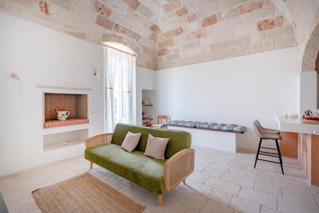 a living room with a green couch and a fireplace at Casita Lemos in Triggianello