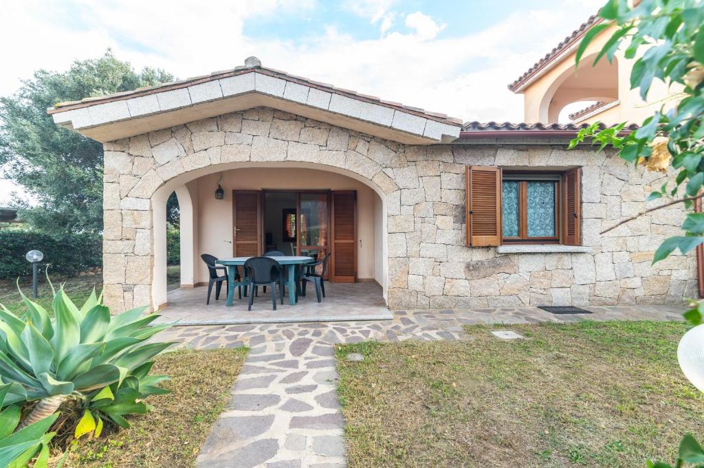 a patio of a house with a table and chairs at Villa San Teodoro in Nuragheddu