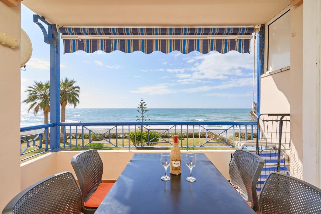 a table with wine glasses and a view of the ocean at Jardines del Mar in Torrox