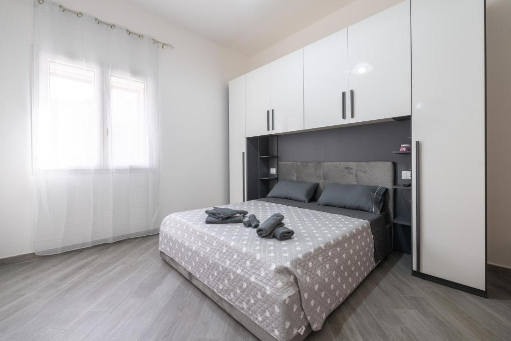 a bedroom with a large bed and white cabinets at Casa Manu in Assemini
