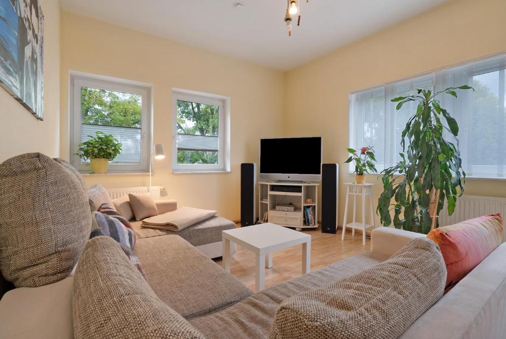 a living room with a couch and a tv at Forst Entdecken in Forst