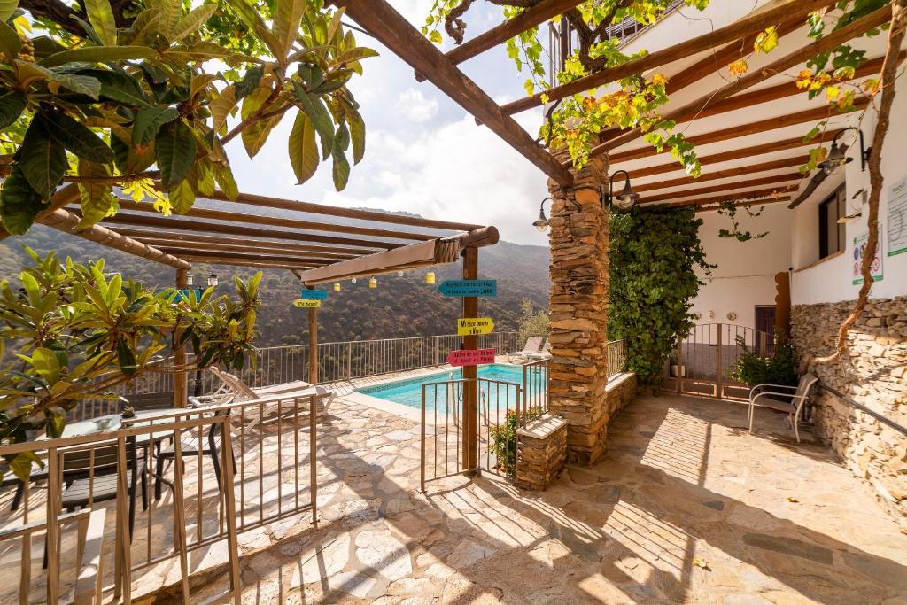 a villa with a swimming pool and a pergola at Picachico in Laroya