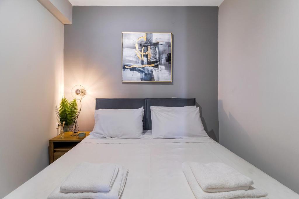 a bedroom with a white bed with two white pillows at Mella Roa - Teal studio in Nydri