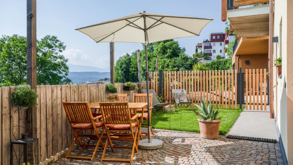 a patio with a table and an umbrella at Meine Bleibe Apartment Terra in Appiano sulla Strada del Vino