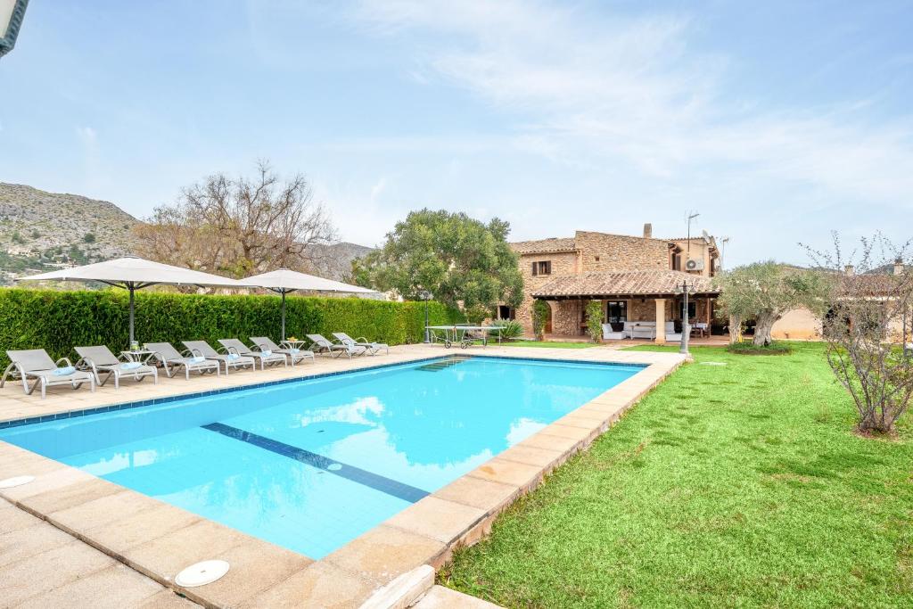 a swimming pool in the yard of a house at Villa Agnes in Pollença