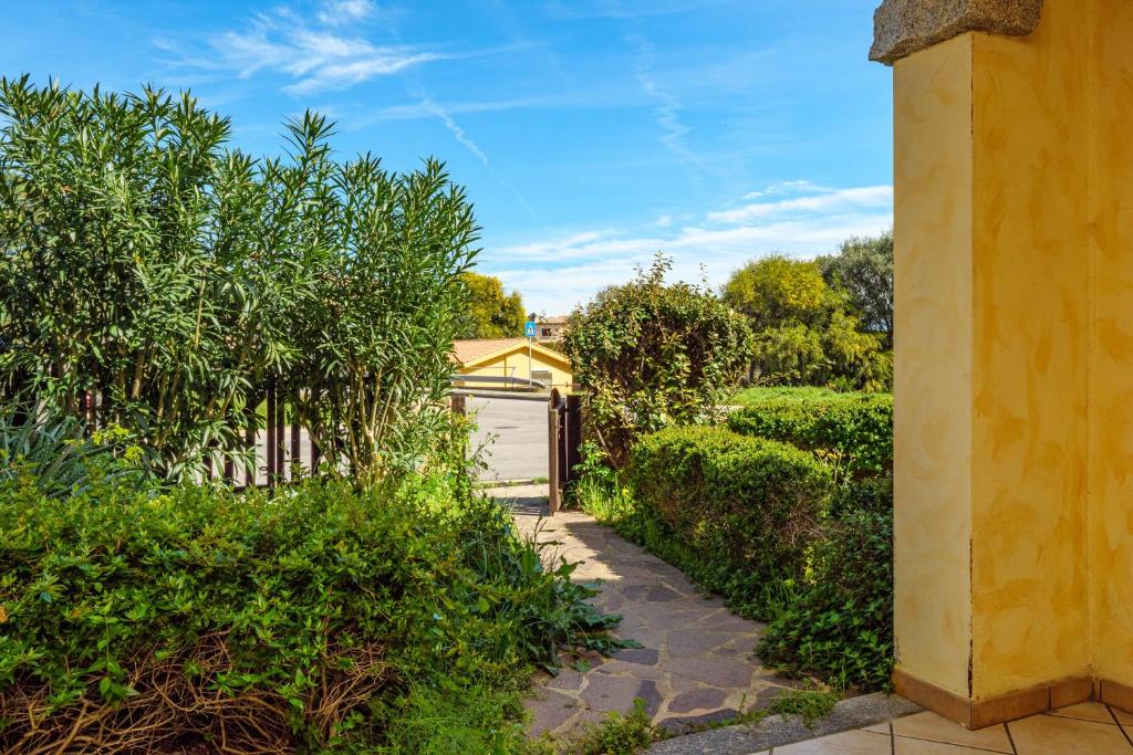 a garden with a fence and a white garage at Residence Orizzonti app n 21 in Golfo Aranci