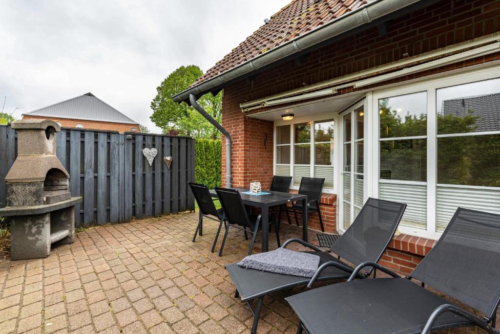 a patio with a table and chairs and a grill at Kleiner Leuchtturm - Steuerbord in Fehmarn