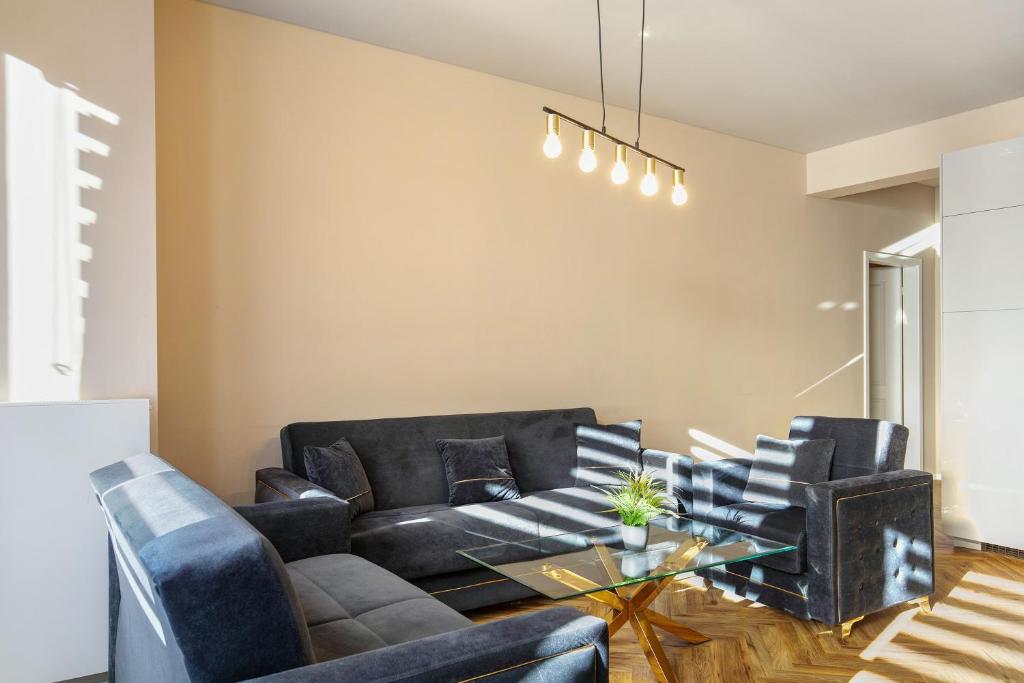 a living room with a black couch and chairs at Hotel zur Panke Wohnung 1 in Kolonie Röntgental