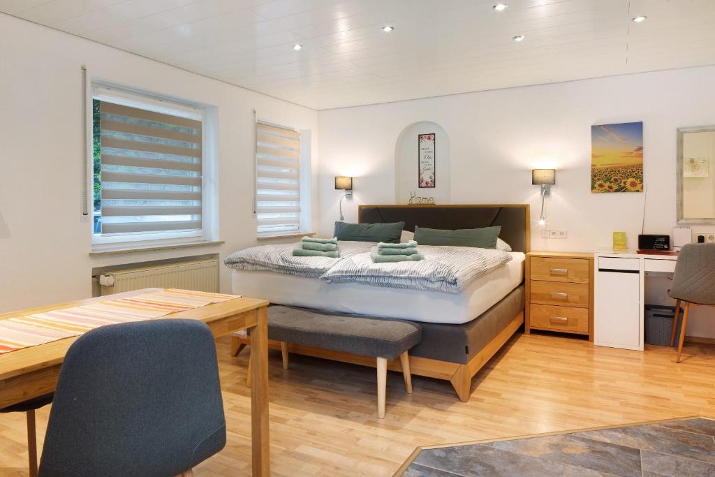 a bedroom with a bed and a table and chairs at Gelis Ferienwohnung in Ihringen