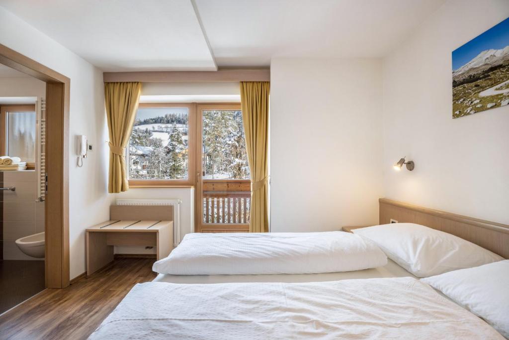 a bedroom with a bed and a window at Runcac Apt Salt in San Vigilio Di Marebbe