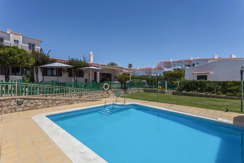 a large blue swimming pool in front of some houses at Villa Morena in Albufeira