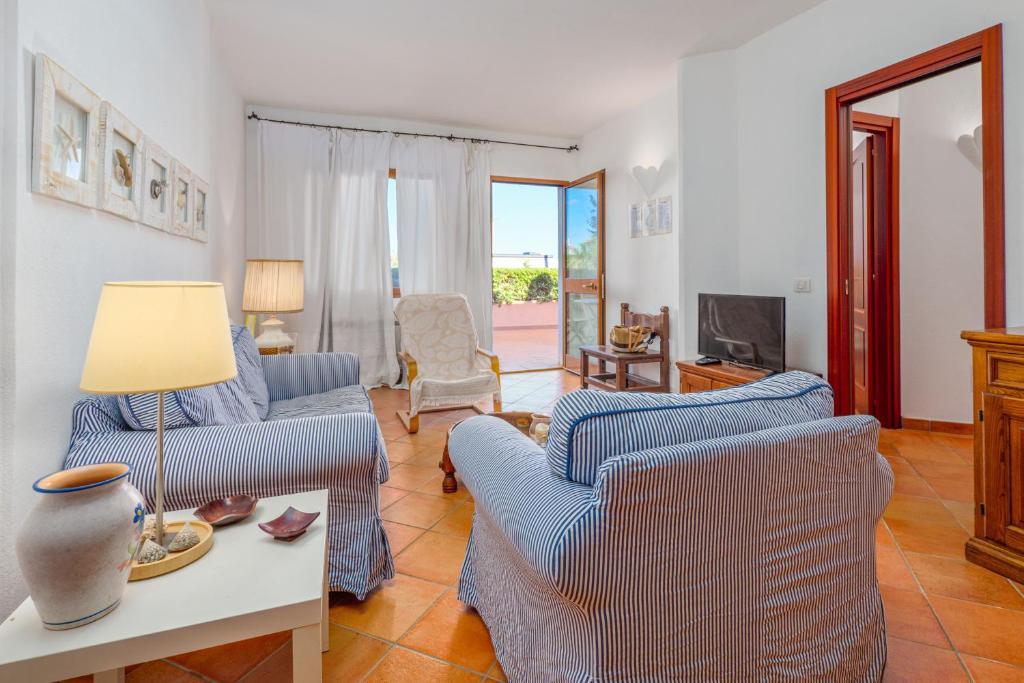 a living room with two blue chairs and a table at Casa Erica in Palau