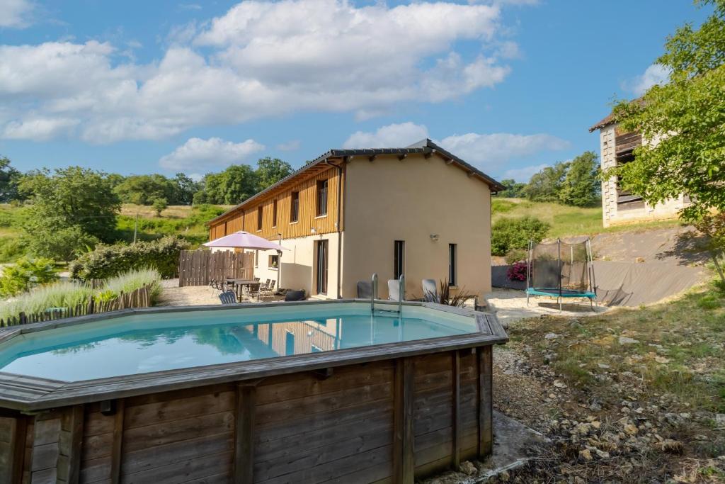 a house with a swimming pool next to a building at Le Séchoir in Saint-Amand-de-Coly