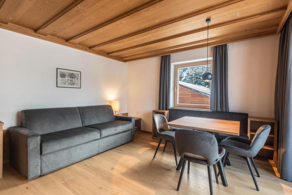 a living room with a couch and a table at La Grambla App Mont Seuc in Santa Cristina Gherdëina