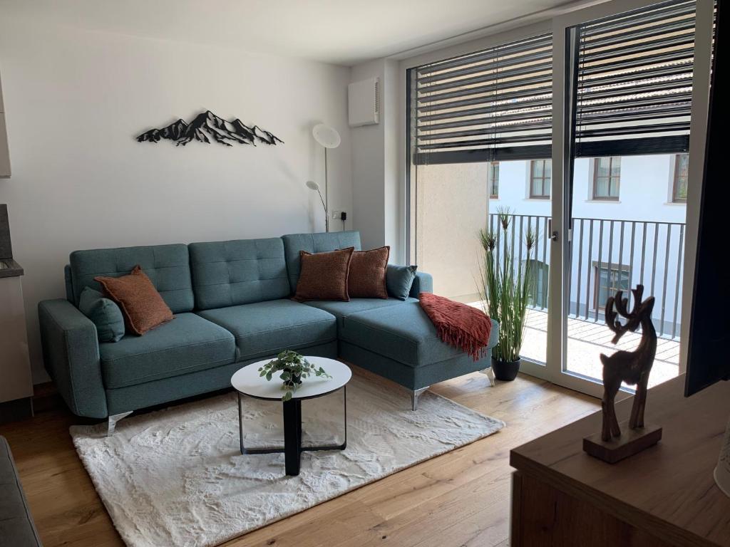 a living room with a blue couch and a table at Apartment Bergzeit Sterzing in Vipiteno