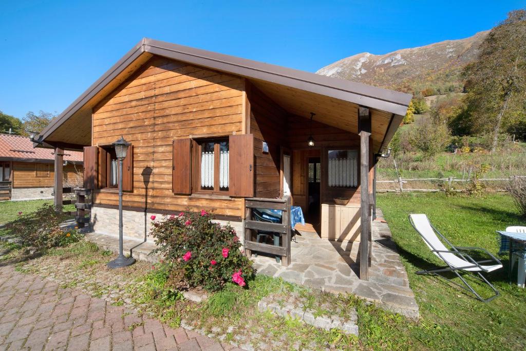 a small wooden cabin with a table and a chair at Casa Genziana in Barzio