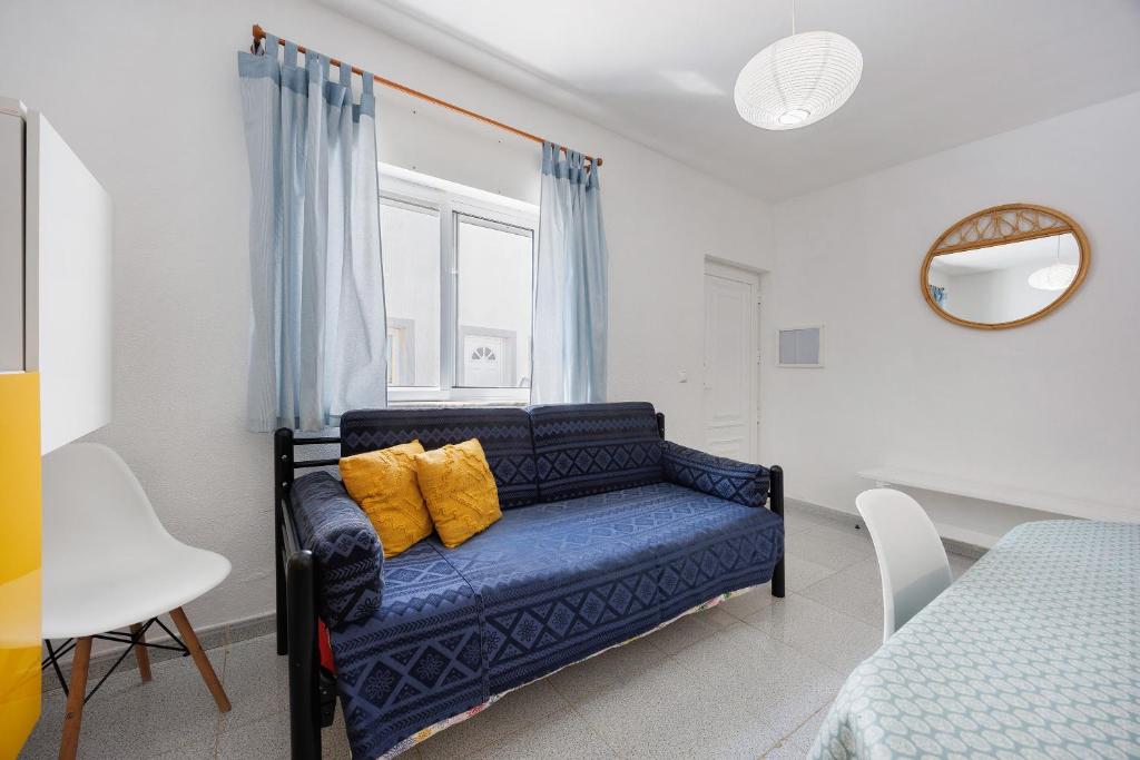 a blue couch in a room with a window at Apartamento Carrapateira in Bordeira