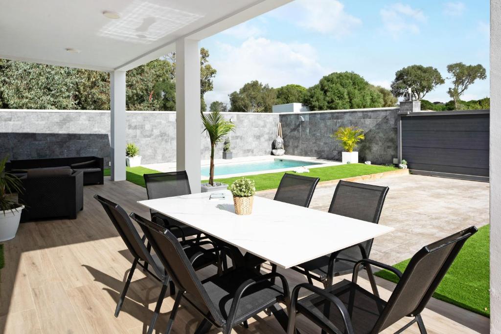 a patio with a table and chairs and a swimming pool at Villa Edén in La Muela