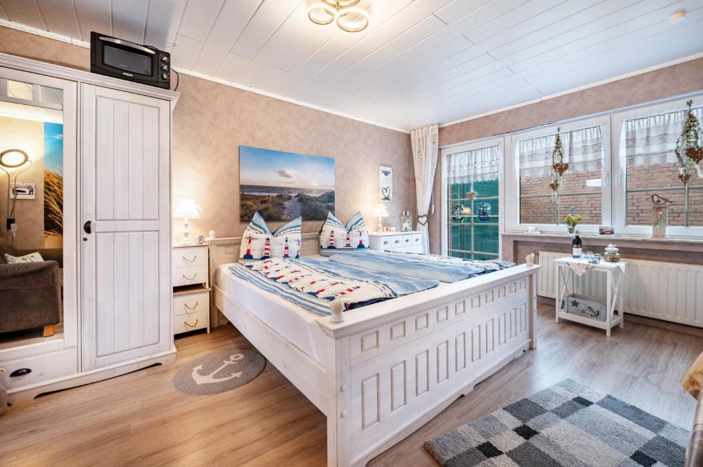 a bedroom with a large white bed in a room at Ferienwohnung Freesenhuus in Wangerland