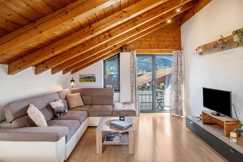 a living room with a couch and a tv at Ferienwohnung Alpenvogel in Sonthofen
