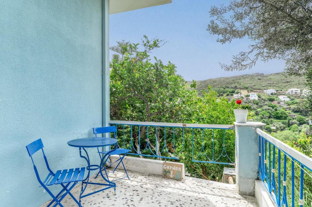 a patio with two chairs and a table on a balcony at Stenies Little Nook in Andros