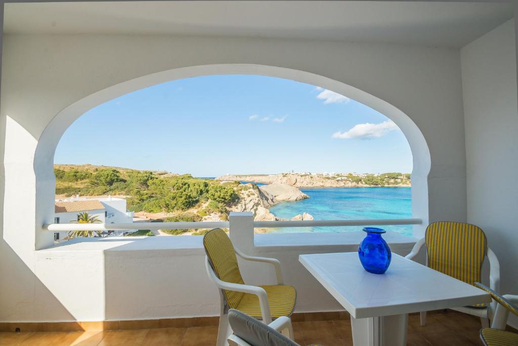 a dining room with a table and a view of the ocean at White Sands 3.08 in Arenal d'en Castell