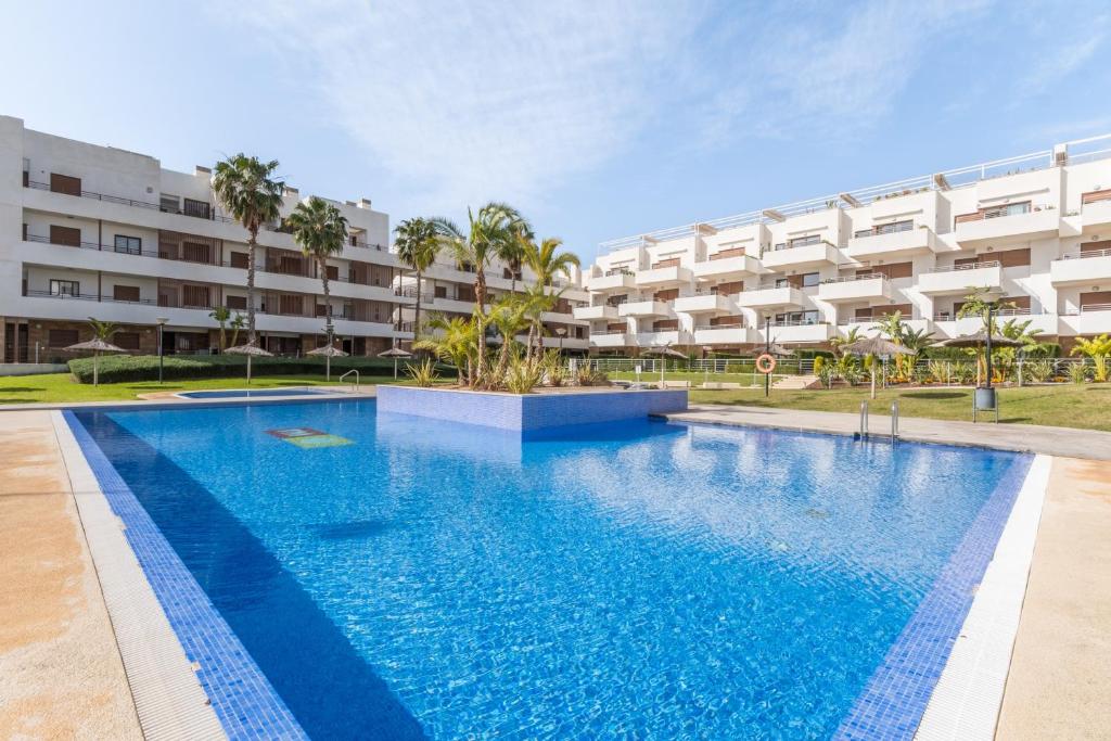a swimming pool in front of a building at Terrazas de Campoamor Sunrise in Orihuela