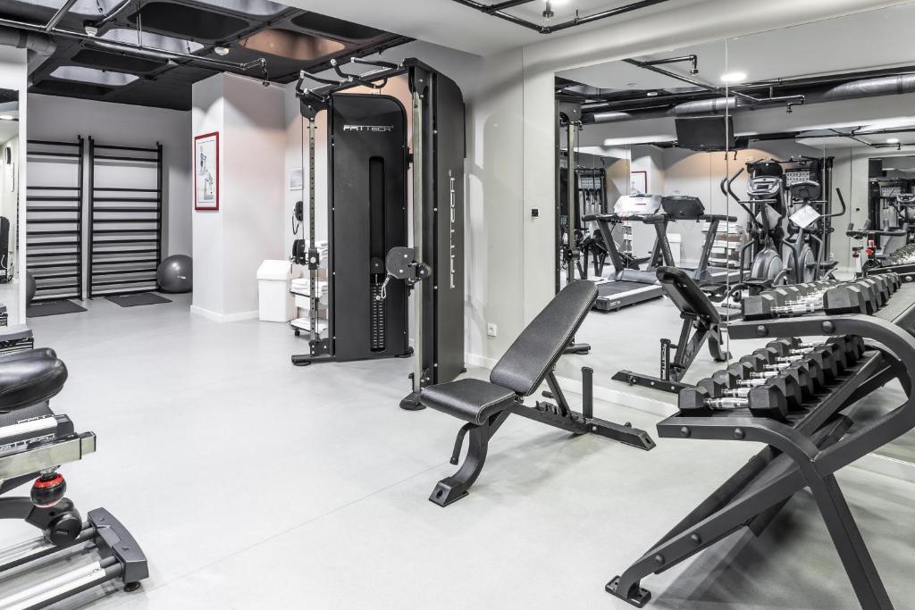 A bright hotel gym with cardio and strength-training equipment.