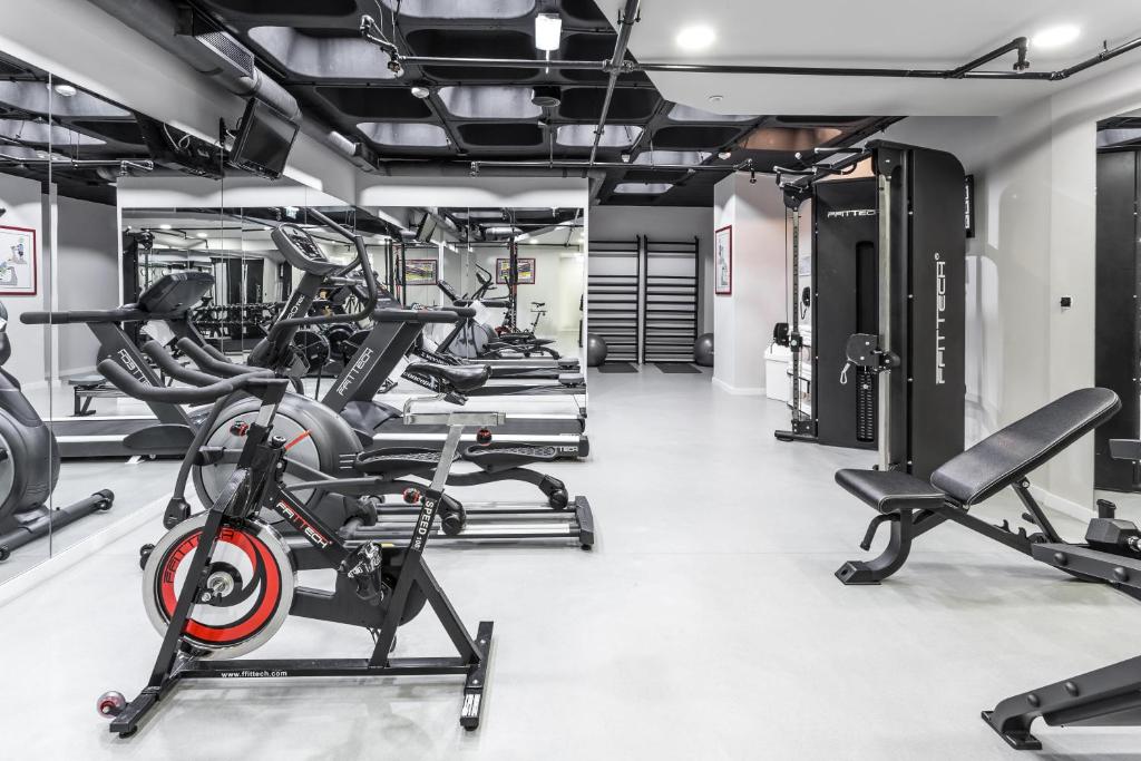 A modern fitness room with cardio machines, cable equipment and free weights.