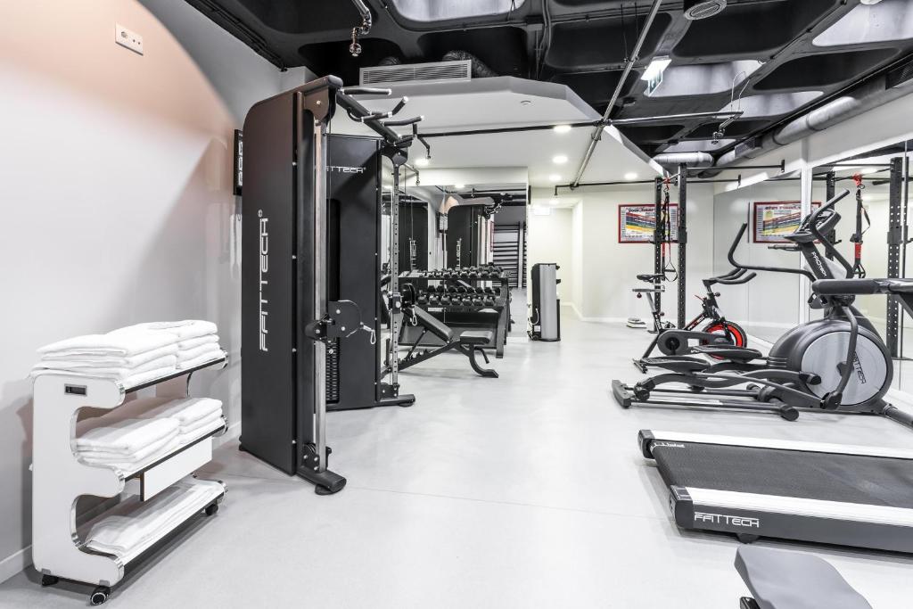A bright fitness room with treadmills, ellipticals and a cable-training station.