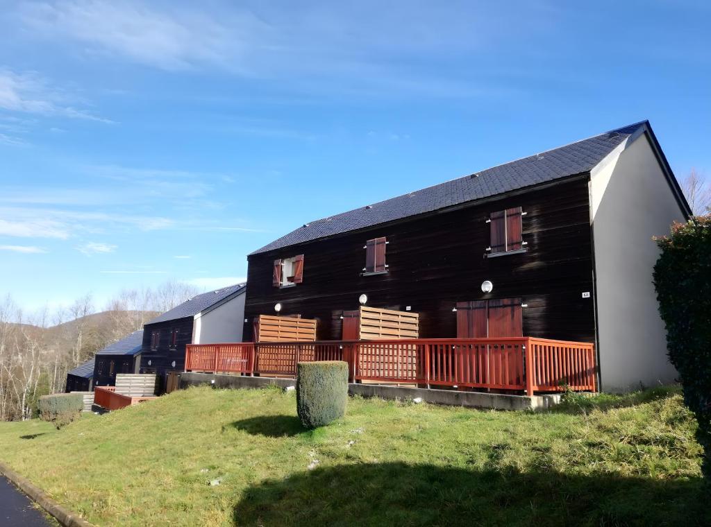 a black and white building on a hill at Duplex Près Du Lac De La Raviège in La Salvetat
