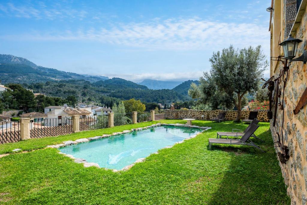 a swimming pool in the grass next to a building at Es Quarteró in Sóller