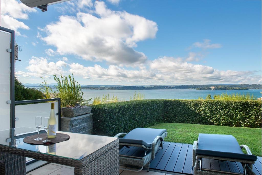 a patio with a table and chairs and a view of the water at Krautter in Uhldingen-Mühlhofen