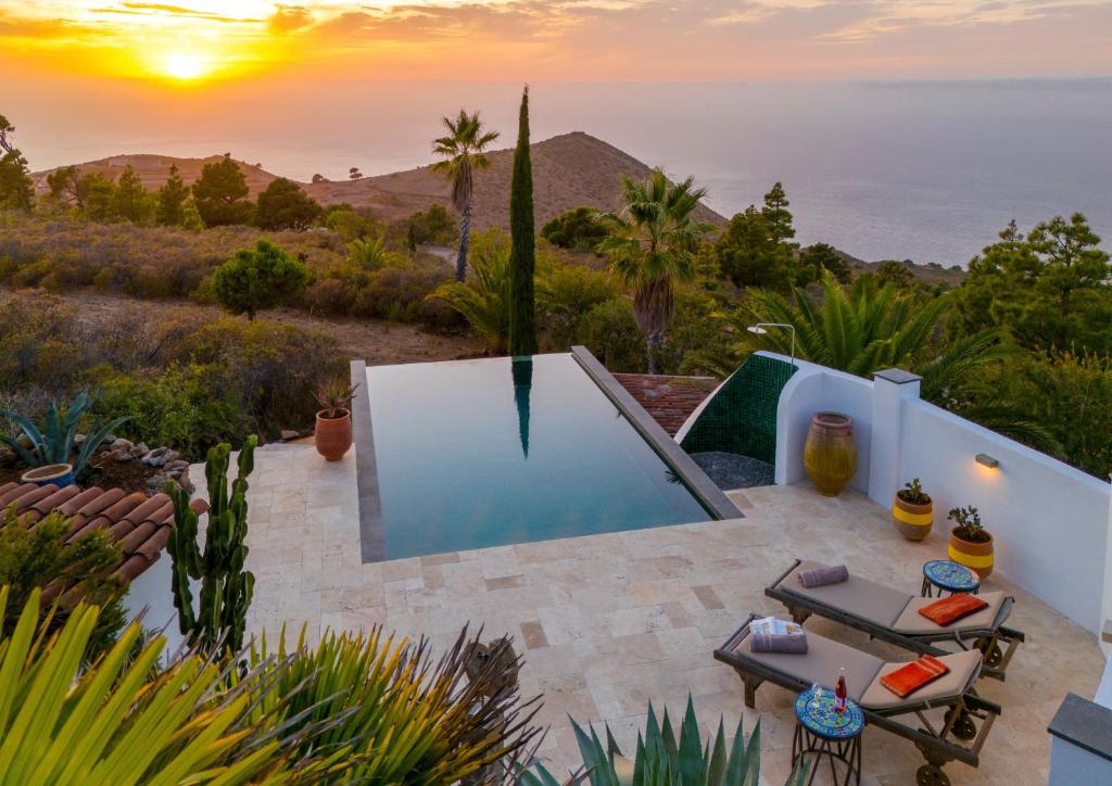 a pool in a backyard with a view of the ocean at Villa Miramar in Puntagorda
